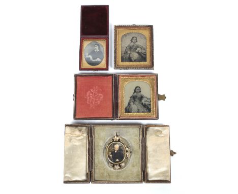 A pair of Victorian daguerotypes of young girls, in gilt frames and leather bound cases; another, oval and smaller; an In Mem