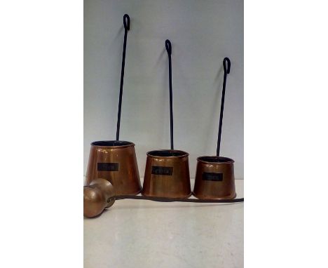 Three graduating copper cider ladles together with a brandy ladle 