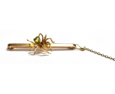 ANTIQUE PERIDOT SPIDER BAR BROOCH9ct gold, 4.8cm long x 2.4mm wide flat bar decorated with a heart shaped peridot and ruby se
