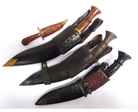 MILITARIA - A KUKRI   the 26cm typically curved blade with a hardwood grip, in its leather sheath, with two small skinning kn