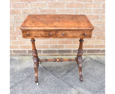 A VICTORIAN WALNUT SIDE TABLE fitted with two short drawers, the two turned supports raised on four outswept legs on ceramic 