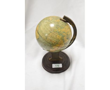 A small vintage tin globe, of traditional arrangement, on a grained tin circular base