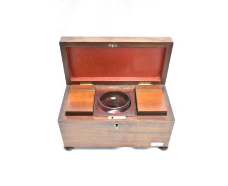 An early 19th Century mahogany tea caddy, having a fitted interior with glass mixing bowl, and raised on squat bun feet, meas
