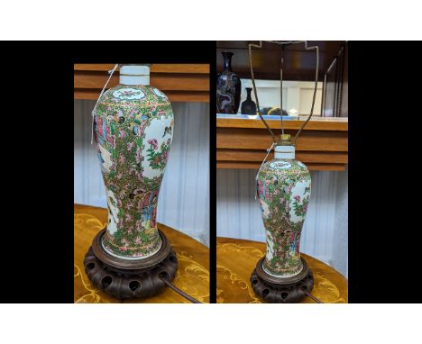 19th/20th Century Chinese Famille Rose Vase converted to a Lamp, raised on a carved wooden base.  Lamp measures 14'' high.
