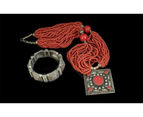 Multi Strand Coral Necklace with square stone set pendant, together with a cuff bangle in white metal.