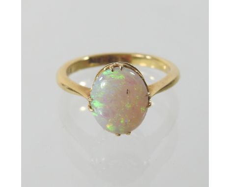 An 18 carat gold opal single stone ring, with an oval cabochon stone