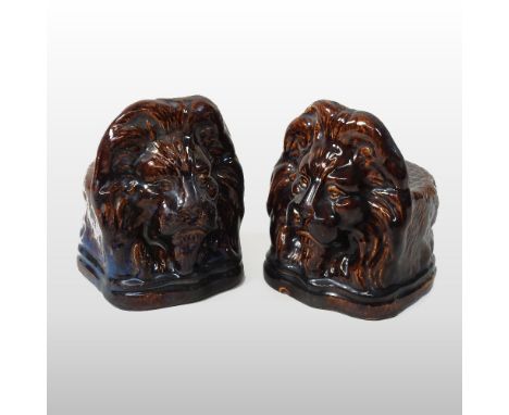 A pair of 19th century Staffordshire treacle glazed sash window supports, each relief decorated with a lion mask, 14cm high