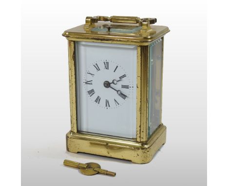 An early 20th century English brass cased carriage clock, of large proportions, having a white enamel dial and push repeat, b