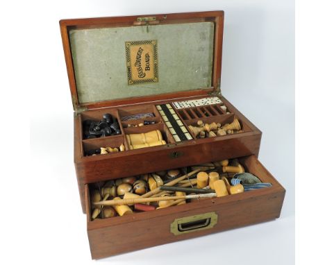 A 19th century mahogany cased games compendium, the fitted interior to include a wooden chess set, bone dominoes, cribbage, a
