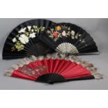 Three large, late 19th century black wood fans, the first with a black satin leaf profusely