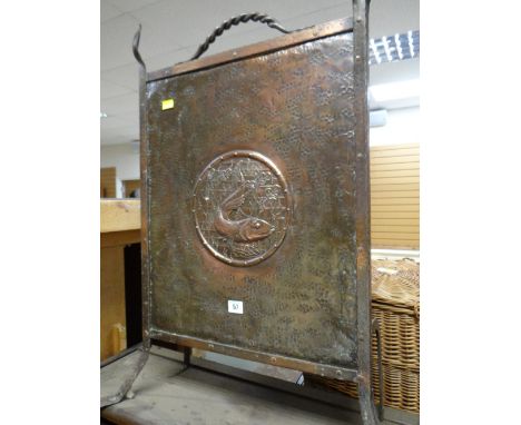 An Arts & Crafts-style beaten copper fire screen with fish cameo