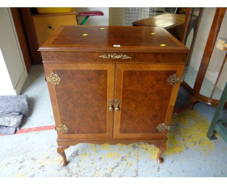 A music cabinet with turn table on cabriole supports with fancy hinges