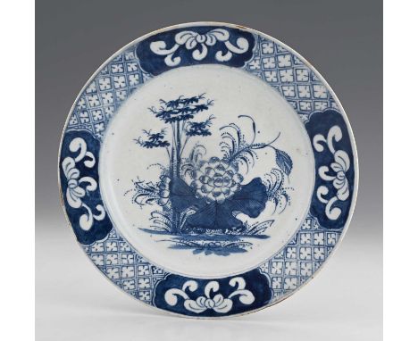 An 18th century Bow porcelain blue and white round plate, painted with Bamboo and Chrysanthemum pattern, within diaper border