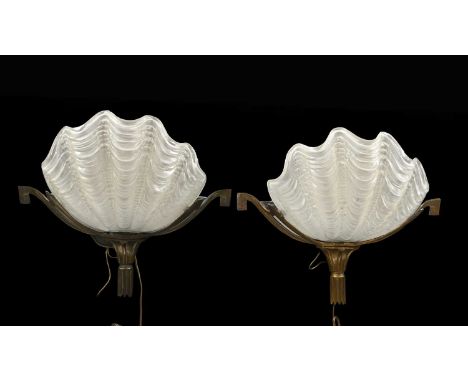 A pair of Art Deco wall lights, 1930s, frosted glass clam shell shades, Odeonesque gilt metal mounts, 30cm high, 32cm wide (2