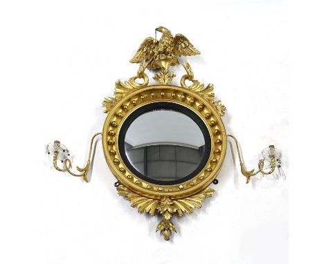 A Regency giltwood twin-light convex girandole, dated 1810, carved giltwood eagle finial with outstretched wings and triple b