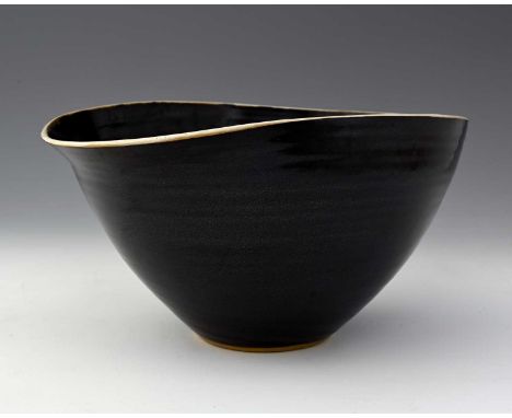 Dame Lucie Rie and Hans Coper, a studio pottery salad bowl, circa 1972, squashed oval form with lip, black manganese tenmoku 