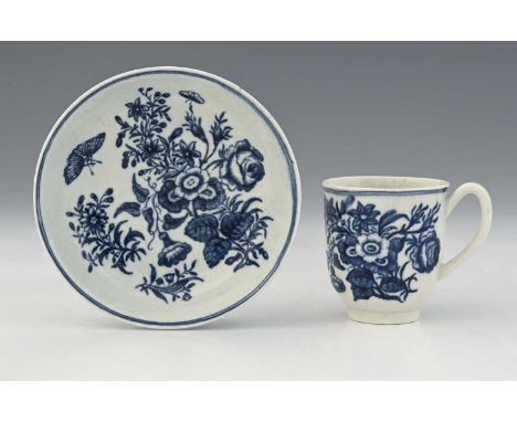 A Worcester blue and white coffee cup and saucer, crescent mark, circa 1775, transfer printed floral pattern, 7cm high (2)