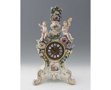 A Meissen florally encrusted figural clock, bombe bracket form, applied with allegorical putti of the seasons, surmounted by 