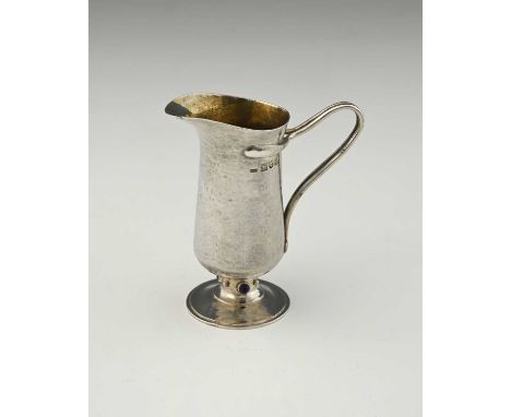Charles Robert Ashbee for the Guild of Handicraft, an Arts and Crafts silver and cabochon set jug, London 1906, planished and