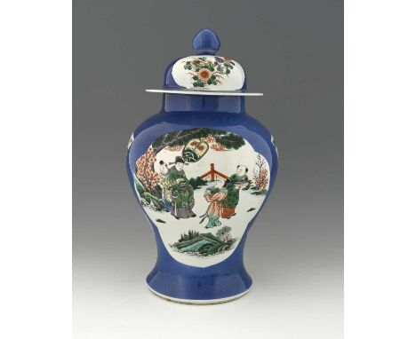 A Chinese powder blue ground famille verte temple vase and cover, decorated with vignettes of courtiers in interior and garde