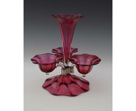 A 19th century ruby glass epergne, optic ribbed central trumpet vase and three bell form bowls, on an ogee domed petal foot, 