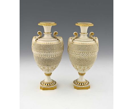 George Owen for Royal Worcester, a pair of reticulated vases, 1909, each of pedestal ovoid urn form, pierced with bands of he