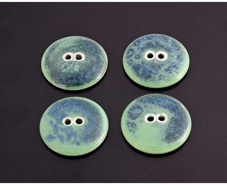 Ruskin Pottery, a set of four Souffle glazed buttons, circular with pierced holes, in curdled blue over green, 3.2cm diameter
