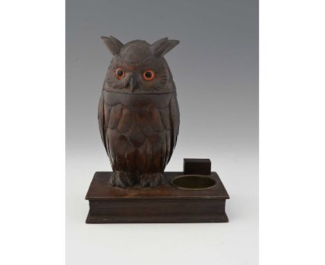 A Black Forest carved cigarette or tobacco box, modelled as an owl, standing on a book, with brass ashtray, the removable hea