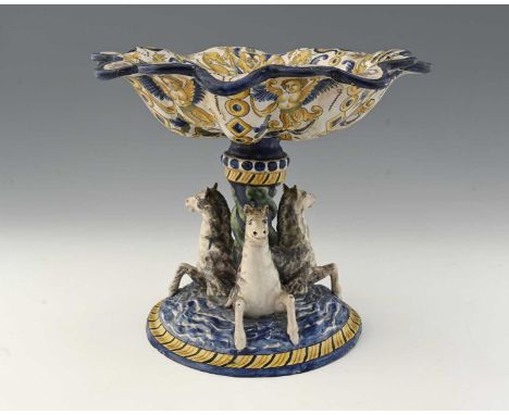 An Italian Faience Majolica tazza or comport, painted with a putto playing a flute with a Renaissance style zoomorphic border
