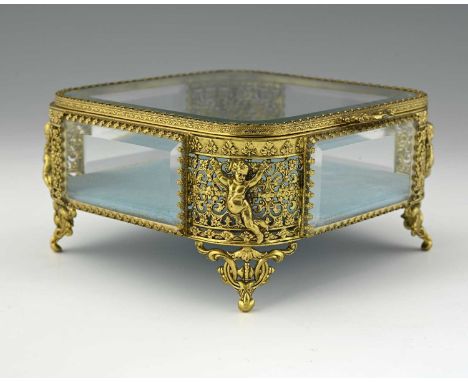 A French Palais Royal style gilt metal and glass paneled jewel casket, square section, embossed reticulated foliate scroll co