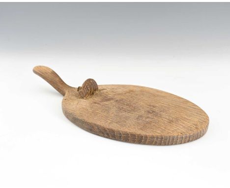 Robert Mouseman Thompson of Kilburn, an Arts and Crafts carved oak cheese board, oval form with handle, relief carved mouse, 