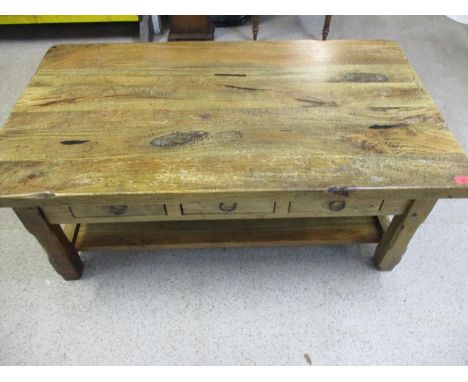 A hardwood coffee table having three small drawers and a shelf below 