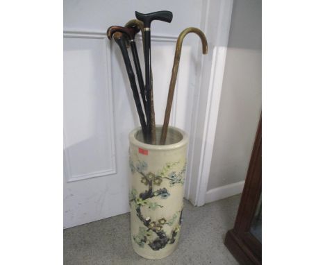 A stick stand with assorted sticks, possibly Chinese 