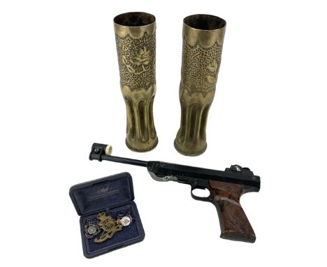 Italian RO71 .177 air pistol, a pair of trench art vases, and a small collection of cap badges