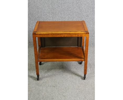 A mid century light oak serving or drinks trolley with spring action drop side. H.66 W.80 D.64cm. 