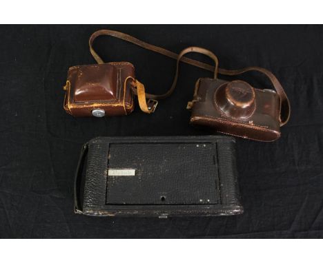 Three vintage cameras by Leica, Kodak and Paxette. H.12 W.25cm. (largest). 