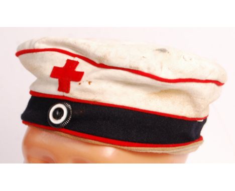 A rare WWI First World War Imperial German Medic's Feldmutze field uniform cap. White, with red piping and red cross to front