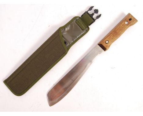 A Gulf War period British military made Golok Machete having a wooden shaped grip, shaped steel wide end blade and canvas fro