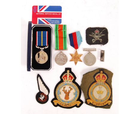 A collection of original WWII Second World War related medals and patches to include; The 1939-1945 Star, 2x Defence Medals, 