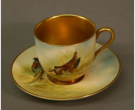 A ROYAL WORCESTER HAND PAINTED CABINET CUP AND SAUCER, the cup painted with a Woodcock, the saucer with a pheasant, both sign