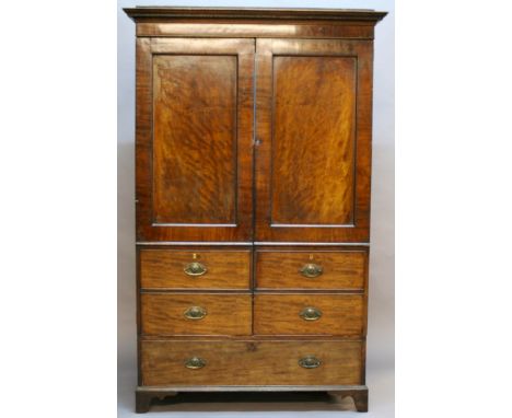 A 19TH CENTURY MAHOGANY CAMPAIGN WARDROBE having a moulded cornice, plain frieze and two panelled doors, the base formed as f
