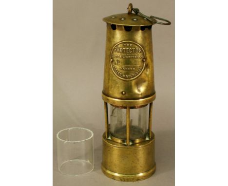 A PROTECTOR LAMP & LIGHTING COMPANY BRASS MINERS' LAMP of typical bonnet and bar construction, stamped number 46569. 26cm(h) 