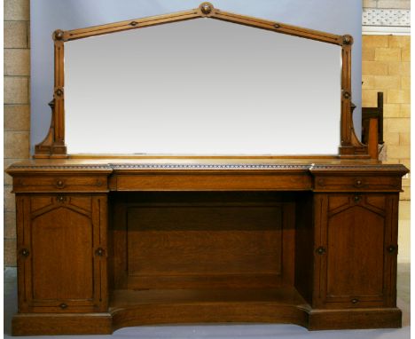 A VICTORIAN OAK MIRROR-BACK SIDEBOARD having an architectural arched plate within a surround ornamented with florets, an inve