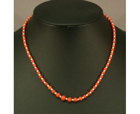 A CORAL AND SEED PEARL NECKLACE spherical coral beads interspersed with seed pearls, finishing with a yellow metal circular c