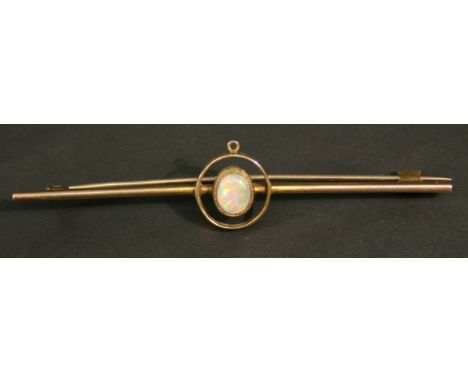 A YELLOW METAL OPAL SET BAR BROOCH, the central oval opal cabochon set in an annular surround mounted to the slender bar, unm