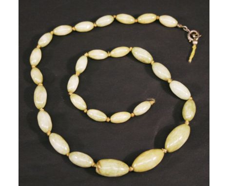 A GREEN STONE BEAD NECKLACE possibly jade, with graduating ovoid beads. 43cm(L) CONDITION: Requires re-stringing, one bead wi