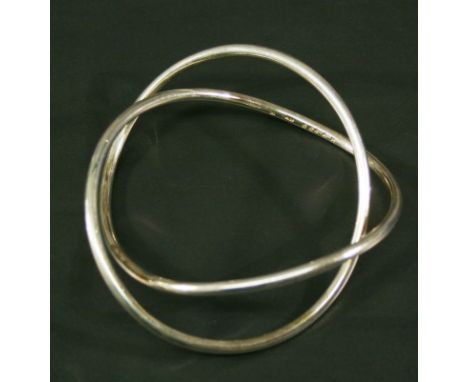 A GEORG JENSEN 925S SILVER 'ALLIANCE' BANGLE number 554 by Alan Scharff, London import marks for 1986, of entwined loop form.