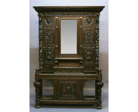 A LARGE VICTORIAN CARVED OAK HALL STAND having a gadrooned cornice, scroll carved frieze and central bevelled oblong mirror p