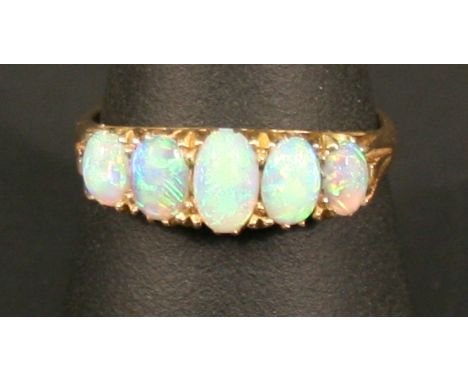 AN EDWARDIAN 18CT GOLD AND OPAL FIVE STONE RING with five graduating oval fiery opal cabochones, the shank marked 18, ring si