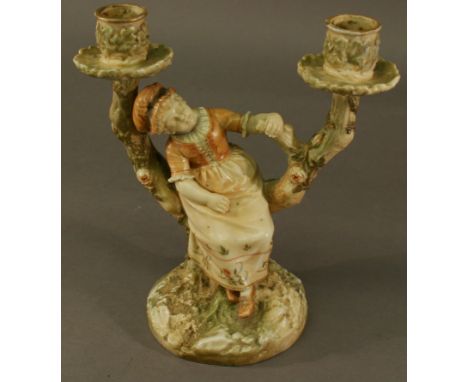 A ROYAL WORCESTER FIGURAL TWO-BRANCH CANDLE HOLDER in the manner of Hadley, formed as a woman seated between two branches, on